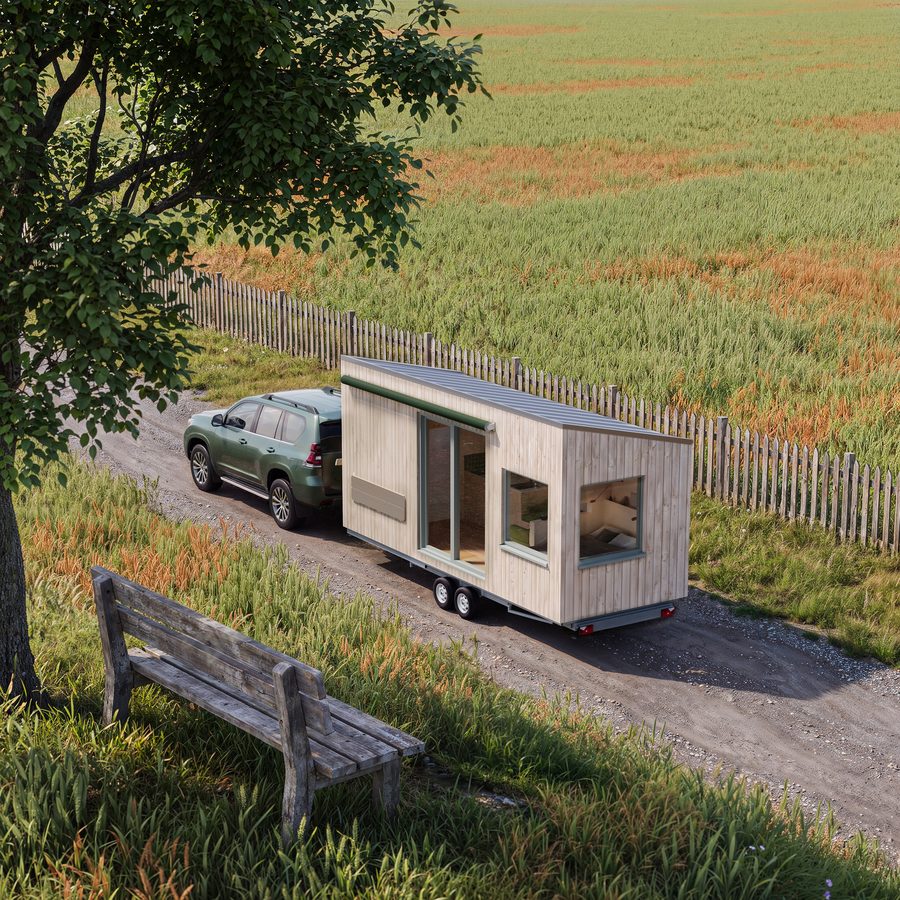 Visualisierung des THOW 3: SUV zieht das helle Tiny House eine baumgesäumte Landstraße entlang, vorbei an einem Holzzaun