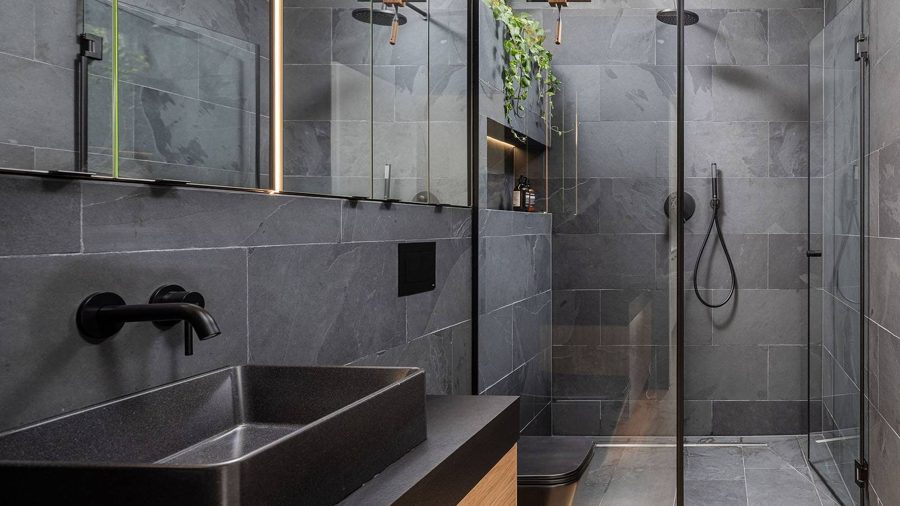 Badezimmer des TR01: dunkler Schiefer, schwarzes Aufsatzbecken, Walk-in-Dusche mit Pflanzen