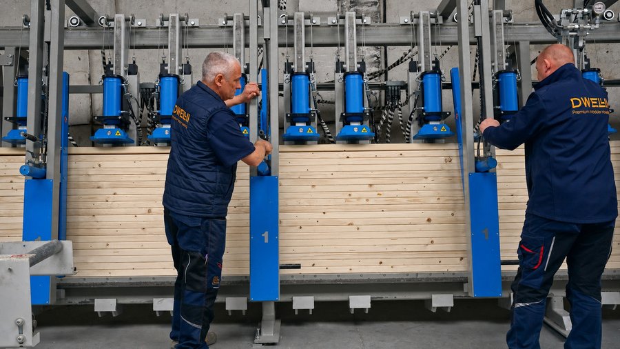 Mitarbeiter bedienen eine industrielle Presse in der DWELLII Fertigung