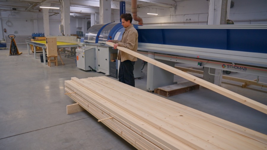 Mitarbeiter bedient eine große Produktionsmaschine in der DWELLII Werkhalle